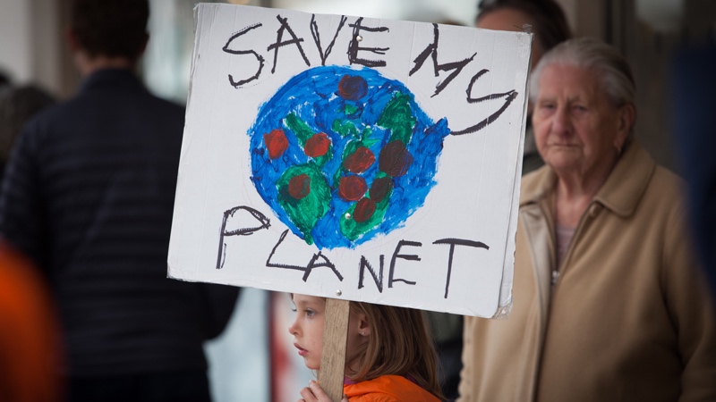 Exeter Youth Strike 4 Climate child holding placard with elderly onlooker