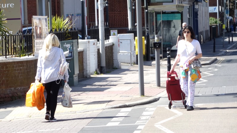 A pedestrian steps into the road to maintain social distance on Queen Street, Exeter
