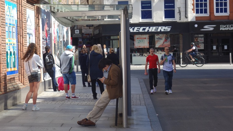 Pedestrians step into the road to maintain social distance beside a supermarket queue on Queen Street, Exeter