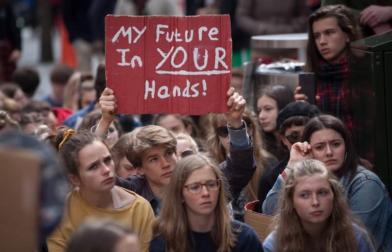 Exeter youth climate strikers holding placard reading "My future in your hands"