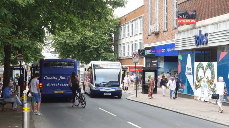 A cyclist, buses and pedestrians on Exeter Fore Street