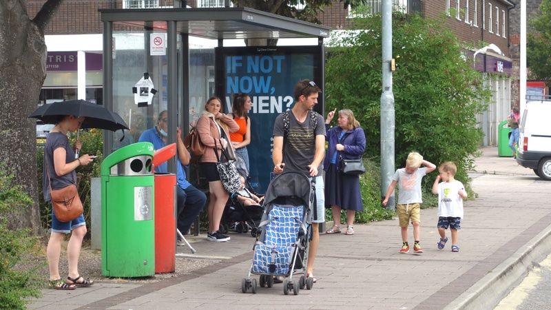 Pedestrians and people waiting at bus stop on Exeter Cowick Street