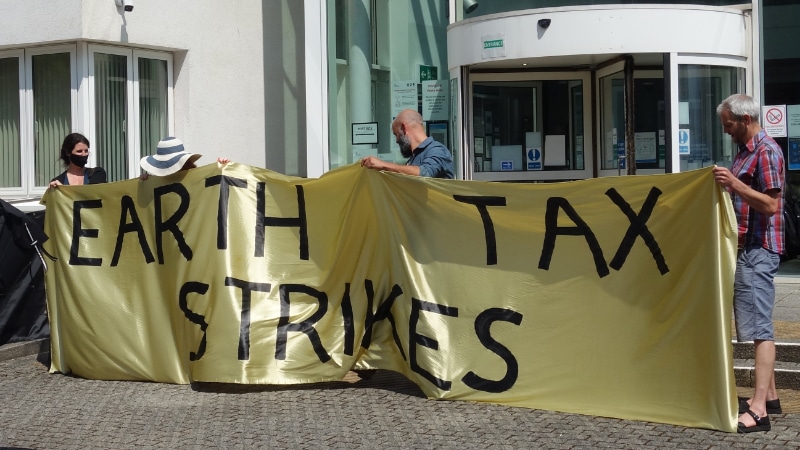 Earth Tax Strikes banner at Exeter Law Courts protest