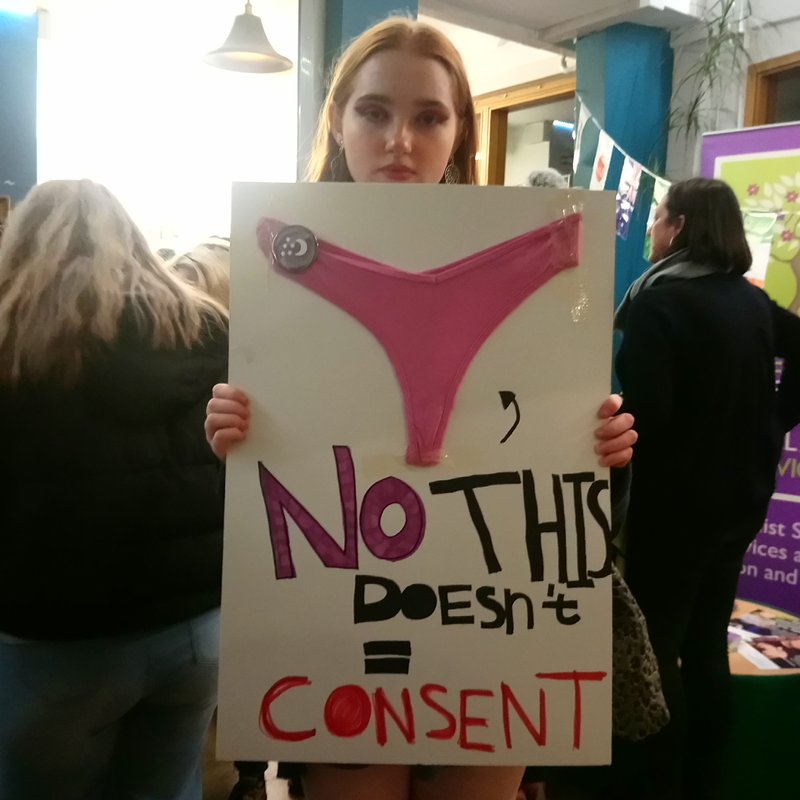 Protester Karina Gilbert holding consent placard before Reclaim the Night march