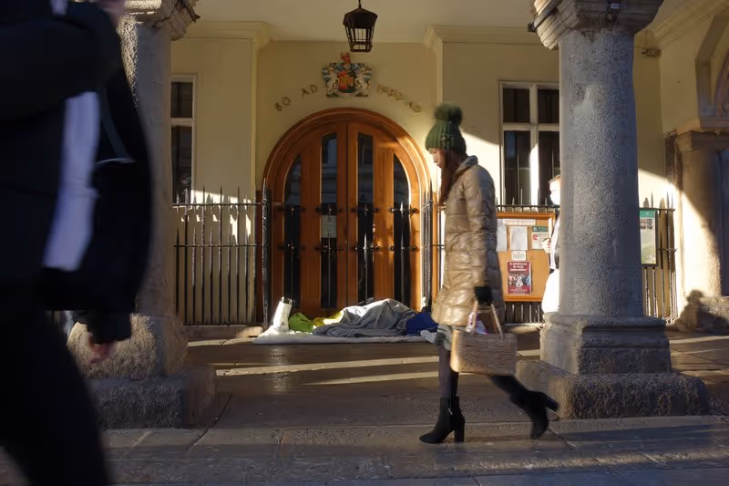 Pedestrians pass a rough sleeper at Exeter Guildhall