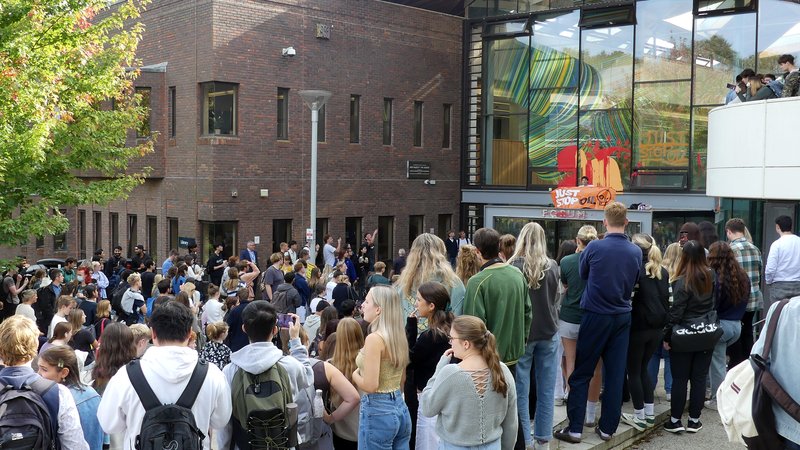 A crowd watches the Just Stop Oil protest at the University of Exeter on 10 October 2023
