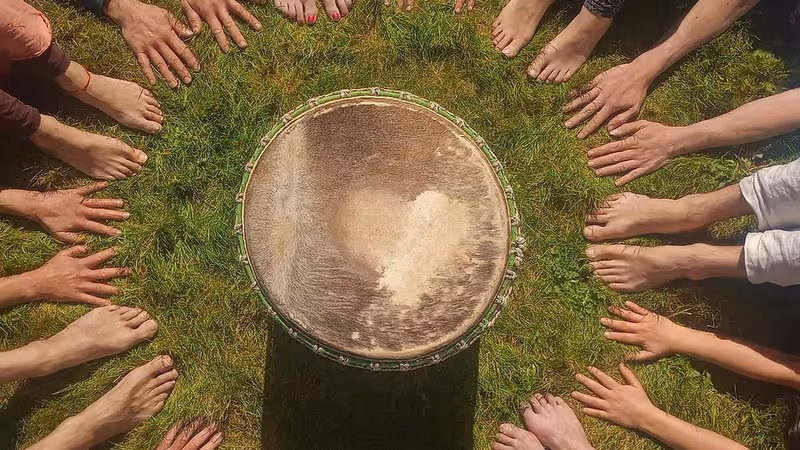 Circle of hands and feet around a drum by Shumba Arts